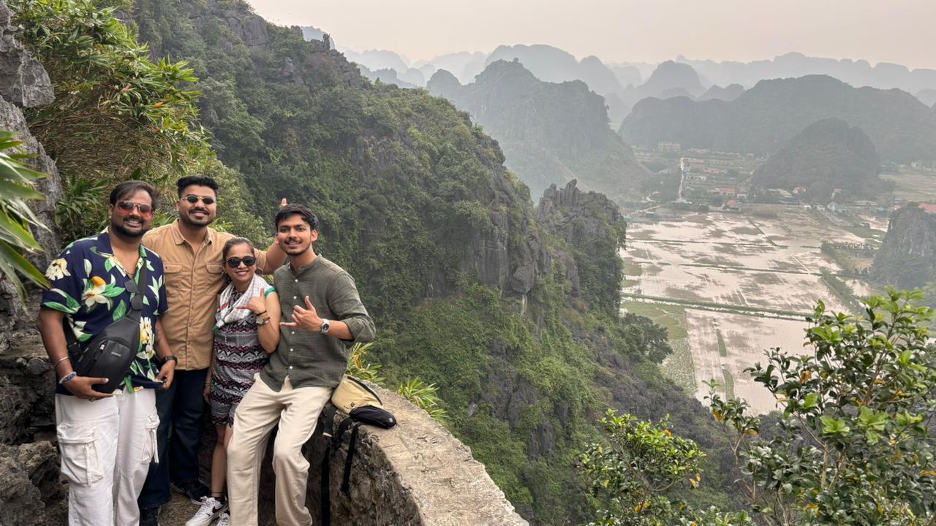 Travellers at a scenic karst viewpoint overlooking rice paddies and mountains