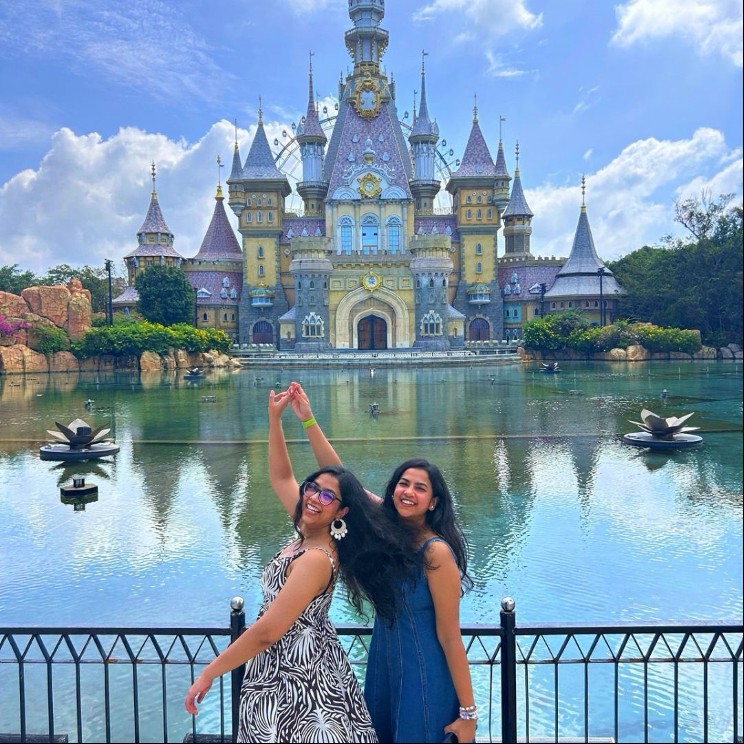 Guests posing by the water with a fairytale castle at VinWonders